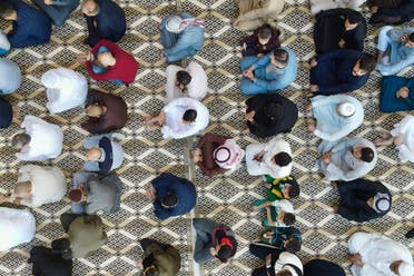 Muslim men listen to a sermon after performing the Eid al-Fitr morning prayer at Al-Nabi Jirjis mosque in Mosul in northern Iraq on April 10, 2024. (AFP)