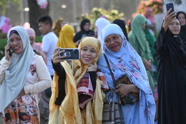 Muslims take selfies after attending Eid al-Fitr prayers, marking the end of the holy month of Ramadan, at a park in Manila on April 10, 2024. (AFP)