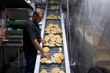 A Palestinian worker arranges freshly baked flatbread at a bakery in Gaza City on April 14, 2024, amid the ongoing conflict between Israel and the militant group Hamas. (AFP)