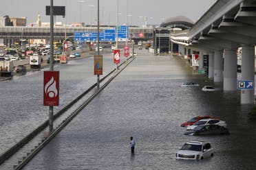 A person stands surrounded by flood water caused by heavy rains, in Dubai, United Arab Emirates, April 17, 2024. (Reuters)