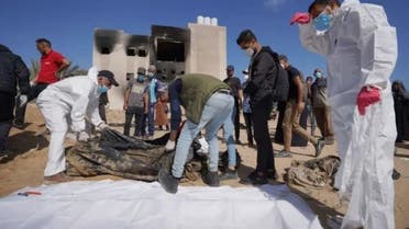 Λεζάντα: Παλαιστίνιοι εργαζόμενοι στον τομέα της υγείας στέκονται δίπλα στα ανακαλυφθέντα πτώματα που θάφτηκαν από τις ισραηλινές δυνάμεις στο νοσοκομείο Nasser στο Khan Younis στη νότια Λωρίδα της Γάζας στις 21 Απριλίου 2024, καθώς συνεχίζονται οι μάχες μεταξύ των μαχητών της Χαμάς και των ισραηλινών δυνάμεων στην πολιορκημένη παλαιστινιακή επικράτεια. (AFP)