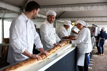 French bakers stand near a large rotating oven in an attempt to beat the world record for the longest baguette during the Suresnes Baguette Show in Suresnes near Paris, France, May 5, 2024. (Reuters)