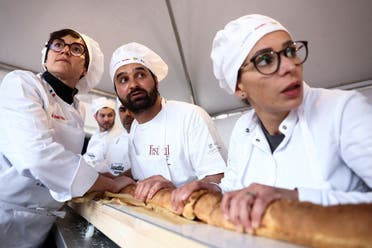 French bakers stand near a large rotating oven in an attempt to beat the world record for the longest baguette during the Suresnes Baguette Show in Suresnes near Paris, France, May 5, 2024. (Reuters)