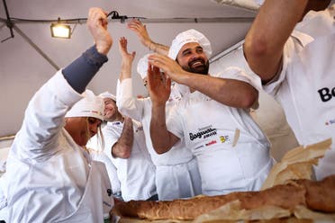 French bakers react after having finished cooking the baguette in an attempt to beat the world record for the longest baguette during the Suresnes Baguette Show in Suresnes near Paris, France, May 5, 2024. (Reuters)
