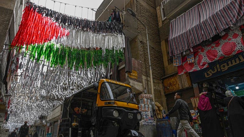 Egyptians walk under Palestinian flag