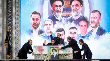 Staff handle the coffin of late Iranian President Ebrahim Raisi during his burial ceremony in the holy shrine of Imam Reza in Mashhad, Iran, May 23, 2024. (Via Reuters)