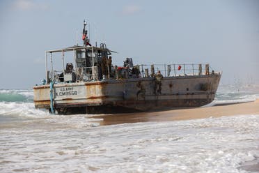 US troops climb a beached vessel used for delivering aid to Palestinians via a new US-built pier in Gaza, after it ran aground along with another aid vessel, May 25, 2024. (Reuters)