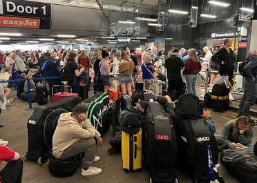 Passengers queue outside Terminal 1 after an overnight power cut led to disruptions and cancellations at Manchester Airport in Manchester, Britain, June 23, 2024. (Reuters)