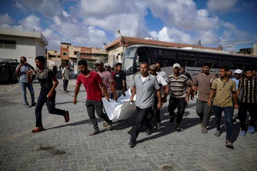 Palestinians carry the body of a person killed by Israeli bombardment in Khan Younis, southern Gaza Strip, July 6, 2024. (AP)