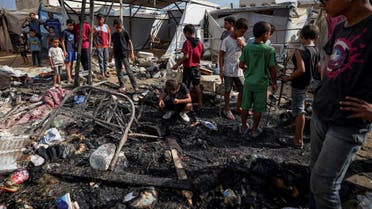 Palestinos inspeccionan los daños en una zona de tiendas de campaña en el patio del hospital de los Mártires de Al-Aqsa, afectado por un bombardeo israelí en Deir al-Balah, el 4 de agosto de 2024. (AP)