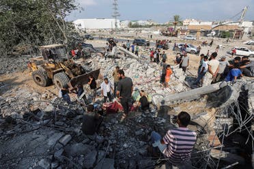 Palestinians stand at the site of an Israeli airstrike on a shelter housing displaced people, amid the conflict between Israel and Hamas, in central Gaza Strip, on August 17, 2024. (Reuters)