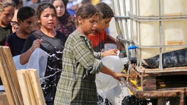 People line up to fill containers with water at a makeshift camp for displaced Palestinians in Deir al-Balah in the central Gaza Strip on August 19, 2024. (AFP) 