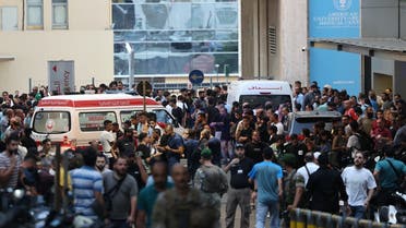 Ambulancias rodeadas de personas a la entrada del Centro Médico de la Universidad Americana de Beirut, el 17 de septiembre de 2024, luego de que explosiones afectaran lugares en varios bastiones de Hezbollah en el Líbano, en medio de las tensiones transfronterizas en curso entre Israel y los combatientes de Hezbollah. (AFP)