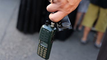 A man holds an Icom walkie talkie device after he removed the battery during the funeral of persons killed when hundreds of paging devices exploded in a deadly wave across Lebanon the previous day, in Beirut's southern suburbs on September 18, 2024. (AFP)