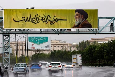 A large banner bearing a picture of Lebanon’s Hezbollah’s late leader Hassan Nasrallah with writing in Farsi that reads “Hezbollah is alive” hangs along a bridge in northern Tehran on September 28, 2024. (AFP)