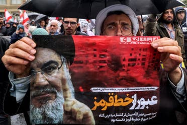 A Shia Muslim cleric holds a poster reading “crossing a red line” in Persian next to an image of Hassan Nasrallah, the late leader of the Lebanese Hezbollah group, during an anti-Israel protest in Tehran’s Palestine Square on September 28, 2024, after Hezbollah confirmed reports of Nasrallah’s killing in an Israeli airstrike in Beirut the previous day. (AFP)