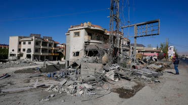 A journalist documents the damaged buildings at the site of an Israeli airstrike, in the village of Temnin, Bekaa Valley, eastern Lebanon, Saturday, Oct. 5, 2024. (AP Photo/Hassan Ammar)