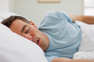 A man sleeps on a bed. (Stock photo)