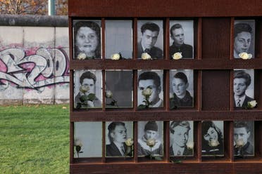 Roses are placed by photographs of victims killed at the Berlin Wall during a ceremony marking the 32nd anniversary of the fall of the Berlin Wall at Bernauer Strasse in Berlin, Germany, November 9, 2021. REUTERS/Christian Mang