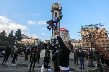  Syrians gather around the Clock Tower during celebrations in the heart of Homs early on December 8, 2024. (AFP)