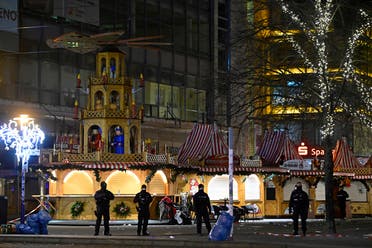 Miembros de las fuerzas de seguridad hacen guardia en la entrada de un mercado navideño donde un automóvil se estrelló contra una multitud hiriendo a más de 60 personas la madrugada del 21 de diciembre de 2024 en Magdeburgo, este de Alemania. (AFP)