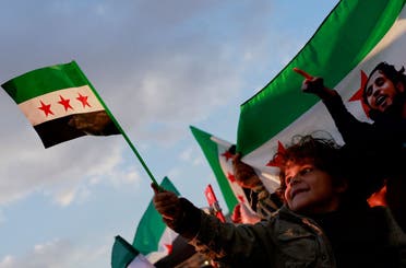 A child holds a Syrian flag as people gather during a celebration called by at the Umayyad Square, after the ousting of Syria’s Bashar al-Assad, in Damascus, December 20, 2024. (Reuters)