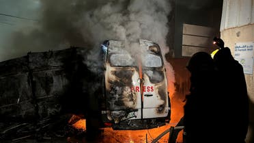 Civil Defense members put out a fire in a broadcast van following an Israeli strike that killed five journalists of Al-Quds Al-Youm television channel, according to medics with the Gaza health authorities, in the vicinity of Al-Awda hospital in Nuseirat in central Gaza December 26, 2024. (Reuters)