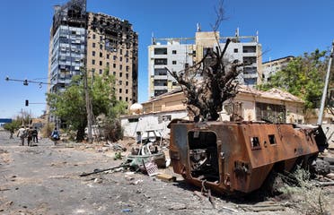 مركبة عسكرية مدمّرة ومبانٍ تعرضت للقصف، في ولاية الخرطوم، السودان، بتاريخ 26 مارس 2025 - فرانس برس