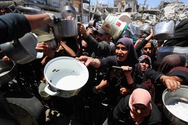 فلسطينيات ينتظرن الحصول على طعام من مطبخ خيري في بيت لاهيا، شمال قطاع غزة - رويترز في 8 مايو 2025