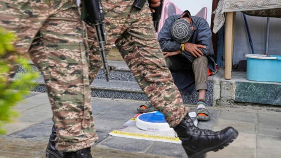 Indian soldiers patrol as a street vendor takes a nap after India and Pakistan reported no incidents of firing overnight, in Srinagar, Indian controlled Kashmir Monday, May 12, 2025. (AP Photo/Mukhtar Khan)