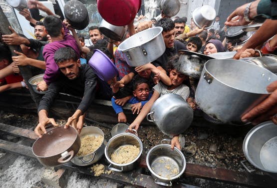 فلسطينيون ينتظرون طعام من مطبخ خيري في جباليا بقطاع غزة - رويترز 14 مايو 2025