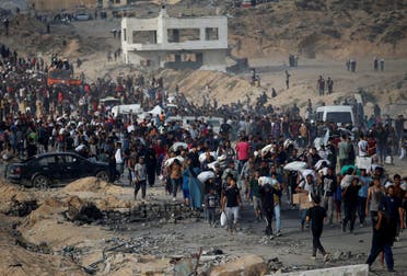 فلسطينيون يحملون مساعدات غذائية في بيت لاهيا شمال قطاع غزة - 23 يونيو 2025 رويترز