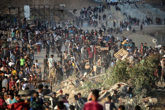 فلسطينيون عند نقطة توزيع مساعدات أنشأتها مؤسسة غزة الإنسانية قرب مخيم النصيرات للاجئين في وسط قطاع غزة - فرانس برس في 25 يونيو 2025