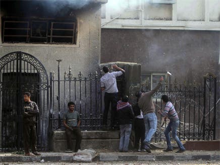 متظاهرون يحاولون إشعال النيران في مجلس الشعب المصري عقب صدامات مع الجيش